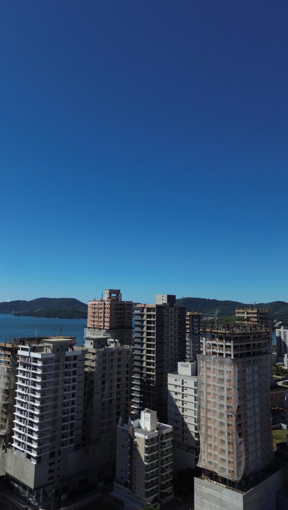 Vista aérea de Balneário Perequê, com prédios ao fundo, capturada por drone.